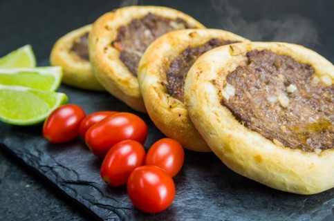 Delicious Lebanese (Arabic) food, genuine sfihas on a slate plate with tomatoes and lemons