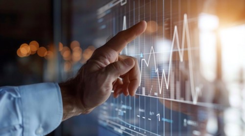 A man is pointing at a graph on a transparent screen showing market and economy trends, AI