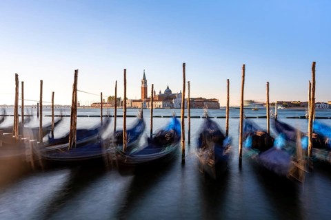 Venetian gondolas, boat dock at St Mark's Square, church of San Giorgio Maggiore in the background,