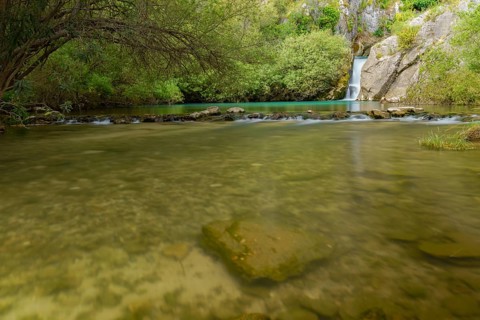 Waterfall of a mountain river with lush vegetation silk effect long exposure photography