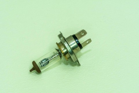 Automobile halogen headlamp bulb isolated on textured background