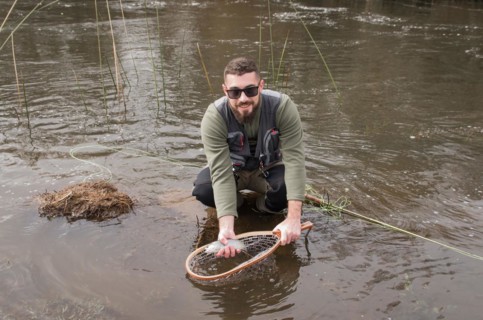 Fisherman fly fishing rainbow trout on mountain in beautiful scenery