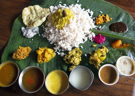Sadya or variety of traditional vegetarian dishes served for lunch on a banana leaf, Kerala, India,