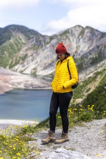 Young woman in yellow jacket standing in front of a volcano, Chaiten Volcano, Carretara Austral,