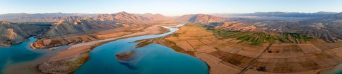 Panorama, Naryn river between mountains and fields, at Toktogul reservoir at sunset, aerial view,