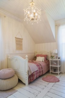 Single bed with red, pink and grey tartan bedspread, white painted antique style wooden headboard