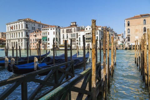 Mooring poles and gondolas on Grand Canal with Renaissance architectural style residential palace