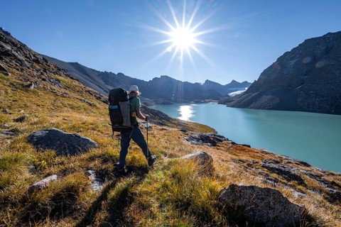 Mountaineers at the turquoise Ala Kul mountain lake in the morning light, Sun Star, Tien Shan
