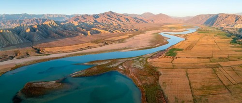 Naryn River between mountains and fields, at Toktogul Reservoir at sunset, aerial view, Kyrgyzstan,