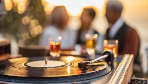 Friends enjoy drinks vinyl record playing together in cozy setting at sunset, bokeh effect ai