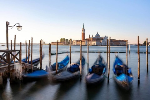 Venetian gondolas, boat dock at St Mark's Square, church of San Giorgio Maggiore in the background,
