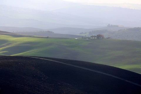 Shadows and light play over the rolling hills of Tuscany at dusk, Italy, Tuscany, Podere Belvedere,
