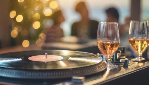 Friends enjoy drinks vinyl record playing together in cozy setting at sunset, bokeh effect ai