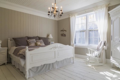 King size bed with light brown and beige striped bedspread, white painted wooden headboard and