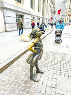 Bronze sculpture Fearless Girl by Kristen Visbal on Broad Street opposite the New York Stock