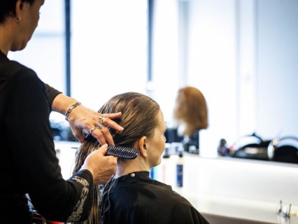 A hairdresser combs her customer's hair, taken in the hairdressing salon Coiffeur Sivan in Berlin,