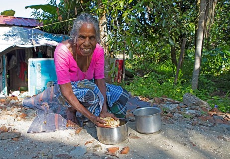 Indian woman, 78 years old, squatting on the floor and washing cassava roots, Kavanattinkara,