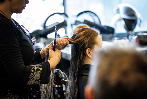 Valentyna Vysotska, hairdresser from Ukraine, combs her customer's hair, taken at the hairdressing