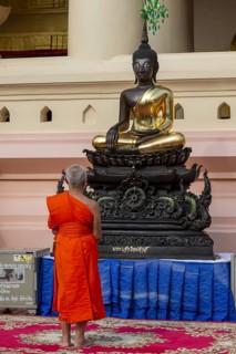 Monk in front of a Buddha statue, Bhumispara-mudra, Buddha Gautama at the moment of enlightenment,