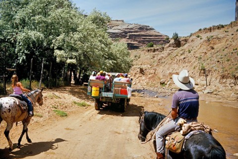 Tourists and horse riders in Canyon de Chelly National Monument, an area of the Navajo Nation in