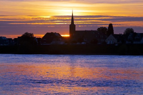 Rhine at sunset with the church of St Dionysius in Volmerswerth, Duesseldorf, Lower Rhine, North