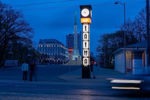 Laima clock, advertising traditional chocolate brand Laima, behind it the Freedom Monument with