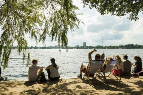 People sitting in the sun by the water, Summer, Outer Alster Lake, Hamburg, Northern Germany,