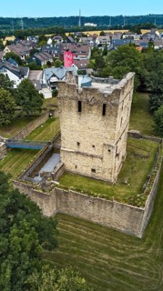 Aerial view of historic ruins of former moated castle with 12th century Romanesque residential