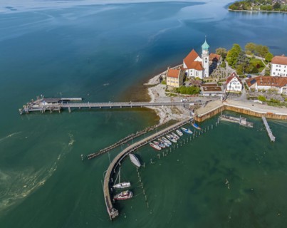 Moated castle peninsula with castle and parish church of St George on Lake Constance. Aerial view,