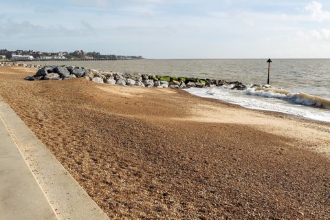 Rock armour groynes building beach sediment, North Sea coast, Felixstowe, Suffolk, England, UK
