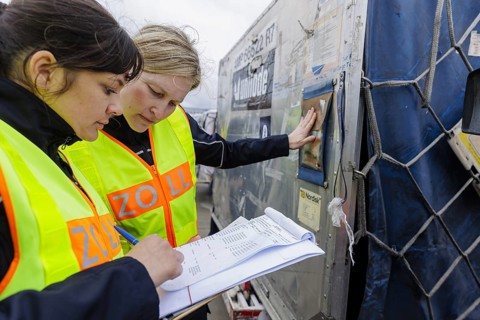 Customs officers check a load of an aircraft that has landed in the cargo area at the airport,