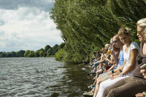 People sitting in the sun by the water, Summer, Outer Alster Lake, Hamburg, Northern Germany,