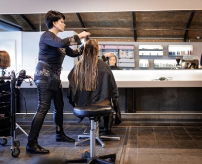 Valentyna Vysotska, hairdresser from Ukraine, combs her customer's hair, taken at the hairdressing