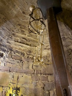 Depiction with artificial skeleton of historical torture at the bottom left of the picture,