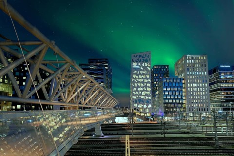 Barcode neighbourhood with acrobats pedestrian bridge night Northern Lights Oslo Norway