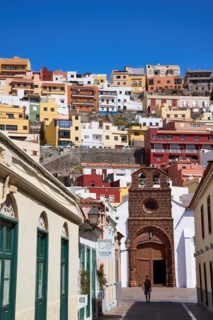 Street in the old town and church Iglesia de Nuestra Senora de la Asuncion, behind colourful houses
