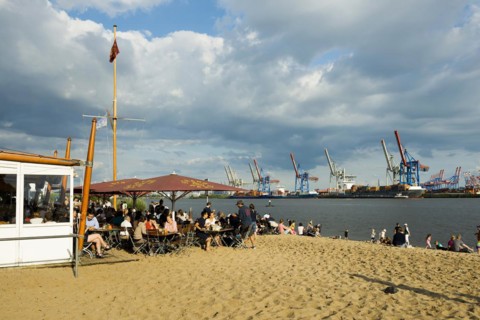 People on the beach, Strandbar Strandperle, Elbe beach, Hamburg harbour in the background,