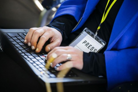 Symbolic photo on the subject of journalism: A journalist types on the keyboard of her laptop and