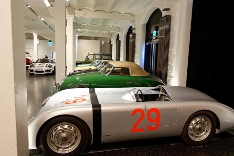 A silver Porsche racing car with starting number 29 is parked among other classic cars, AUTOMUSEUM