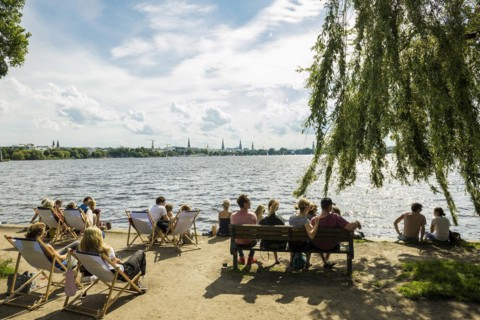 People sitting in the sun by the water, Summer, Outer Alster Lake, Hamburg, Northern Germany,