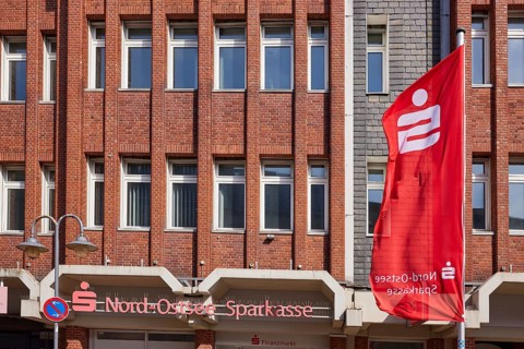 Nord-Ostsee Sparkasse with facade and flag in Husum, district of Nordfriesland, Schleswig-Holstein,