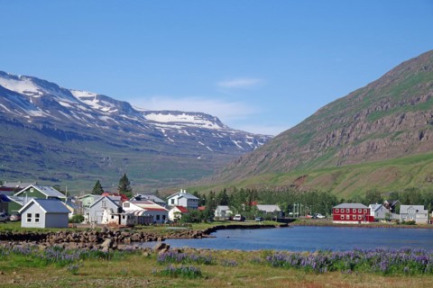 Small village under snow-covered, rugged mountains, ferry town, Seydisfjoerdur, East Iceland,