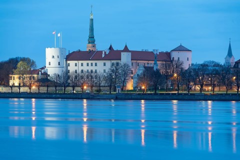 Riga Castle, seat of the Latvian President, in front of the Daugava River at blue hour, Riga,