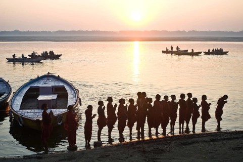 Schoolboys from a gurukul (hindu school), praying the rising sun, praying the hindu god Surya,