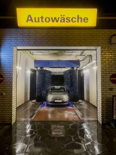 View of Fiat 500 in car wash at night with rotating brushes textile brushes for automatic machine