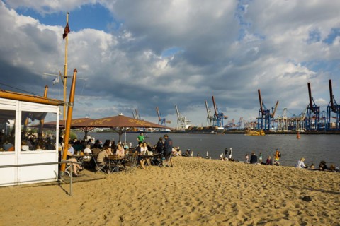 People on the beach, Strandbar Strandperle, Elbe beach, Hamburg harbour in the background,