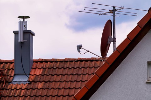 Retrofitted chimney on roof, with dust separator, electrostatic filtering of soot particles from