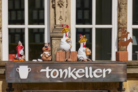 Small figures and the Bremen Town Musicians in front of the entrance to the tonkeller gift shop on