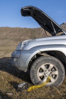 Compressor, inflating a car tyre, off-road vehicle, Kyrgyzstan, Asia