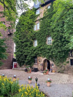 Castle courtyard with green overgrown building of 13th century castle today Burghotel Trendelburg,